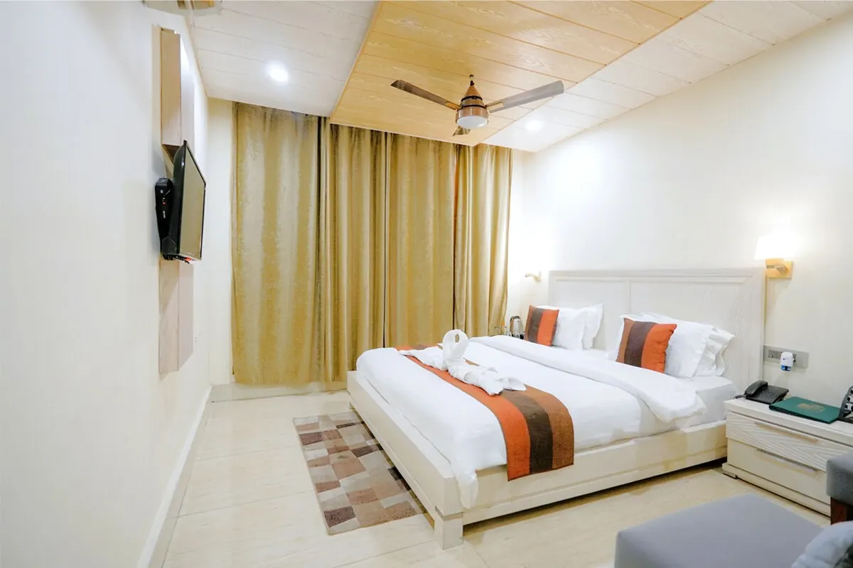 Bright room with twin king beds, wooden ceiling and TV